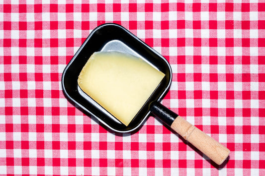 Raclette suisse de montagne, tranche dans un poêlon à raclette