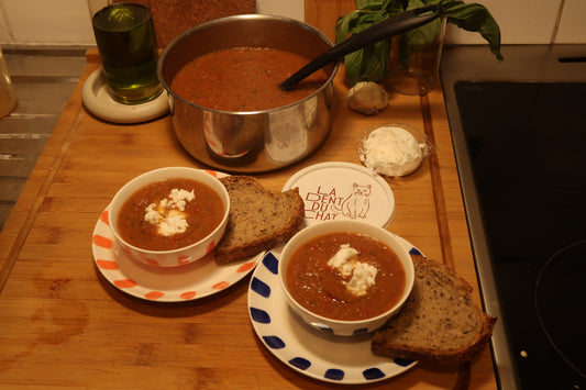 Bol de gaspacho dressé avec dés de fromage frais et herbes ciselées
