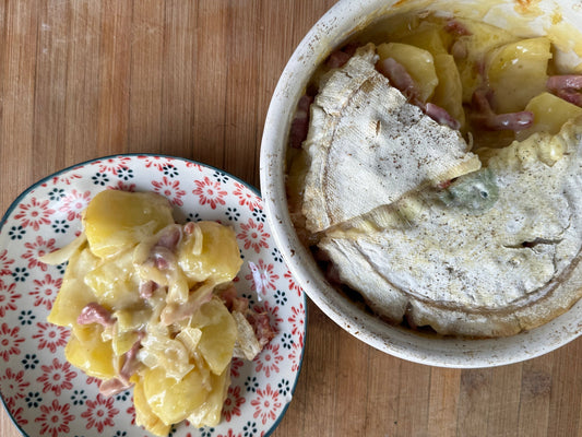 Tartiflette au reblochon fermier fondu, pommes de terre et lardons, servie dans une assiette