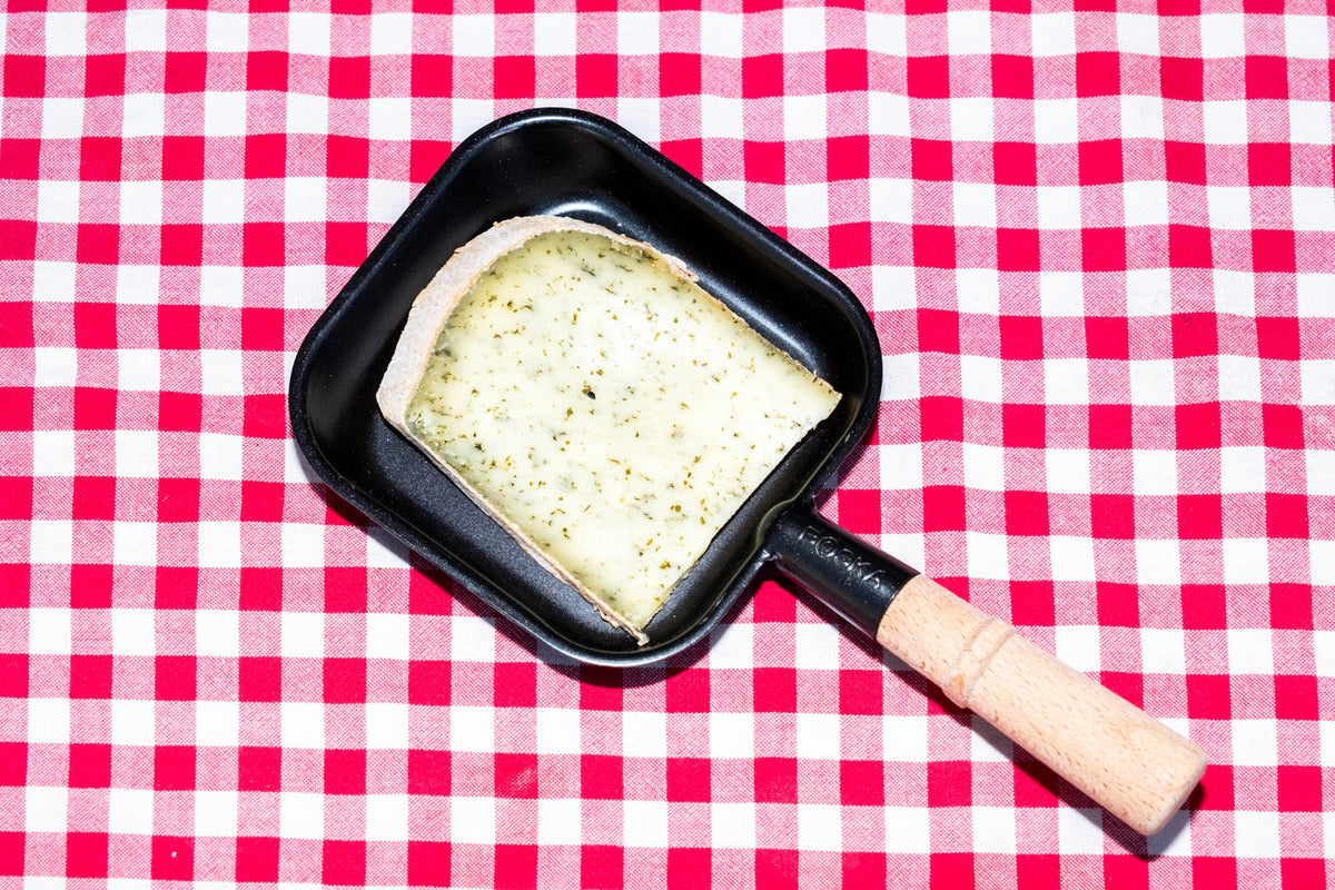 Raclette de Savoie à l'ail des ours, tranche dans un poêlon à raclette