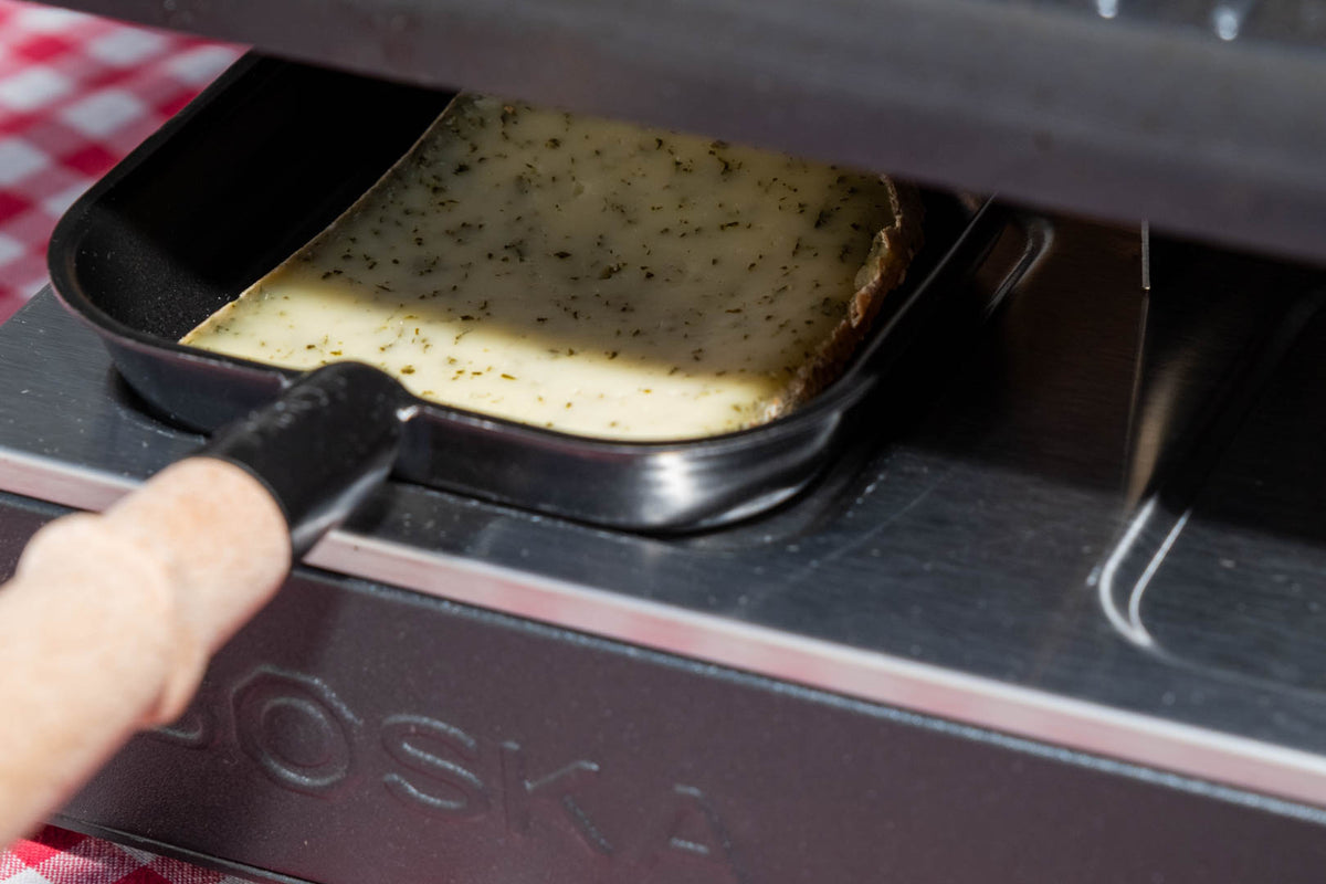 Raclette de Savoie à l'ail des ours, tranche qui fond sous l'appareil à raclette