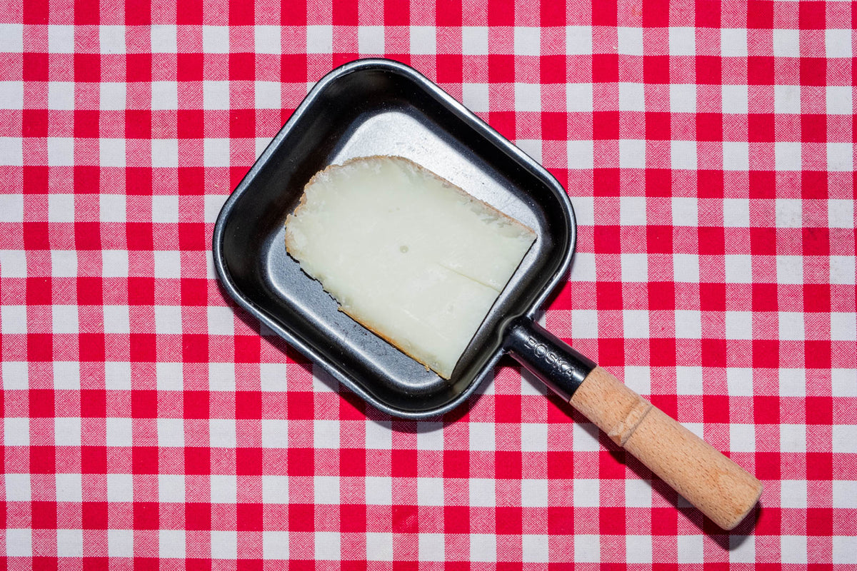 Raclette de chèvre, tranche dans un poêlon à raclette