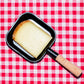Raclette fumée de Haute-Savoie, tranche dans un poêlon à raclette