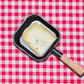 Raclette de Savoie à la moutarde, tranche dans un poêlon à raclette