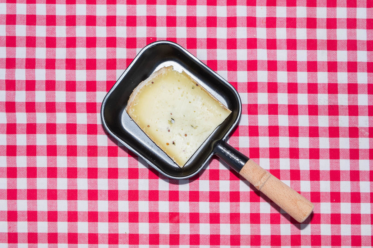 Raclette de Savoie à la moutarde, tranche dans un poêlon à raclette