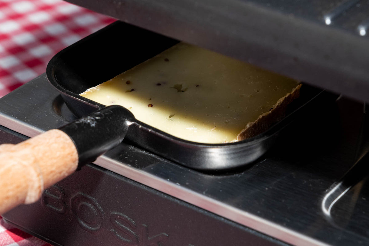 Raclette de Savoie à la moutarde, tranche qui fond sous l'appareil à raclette