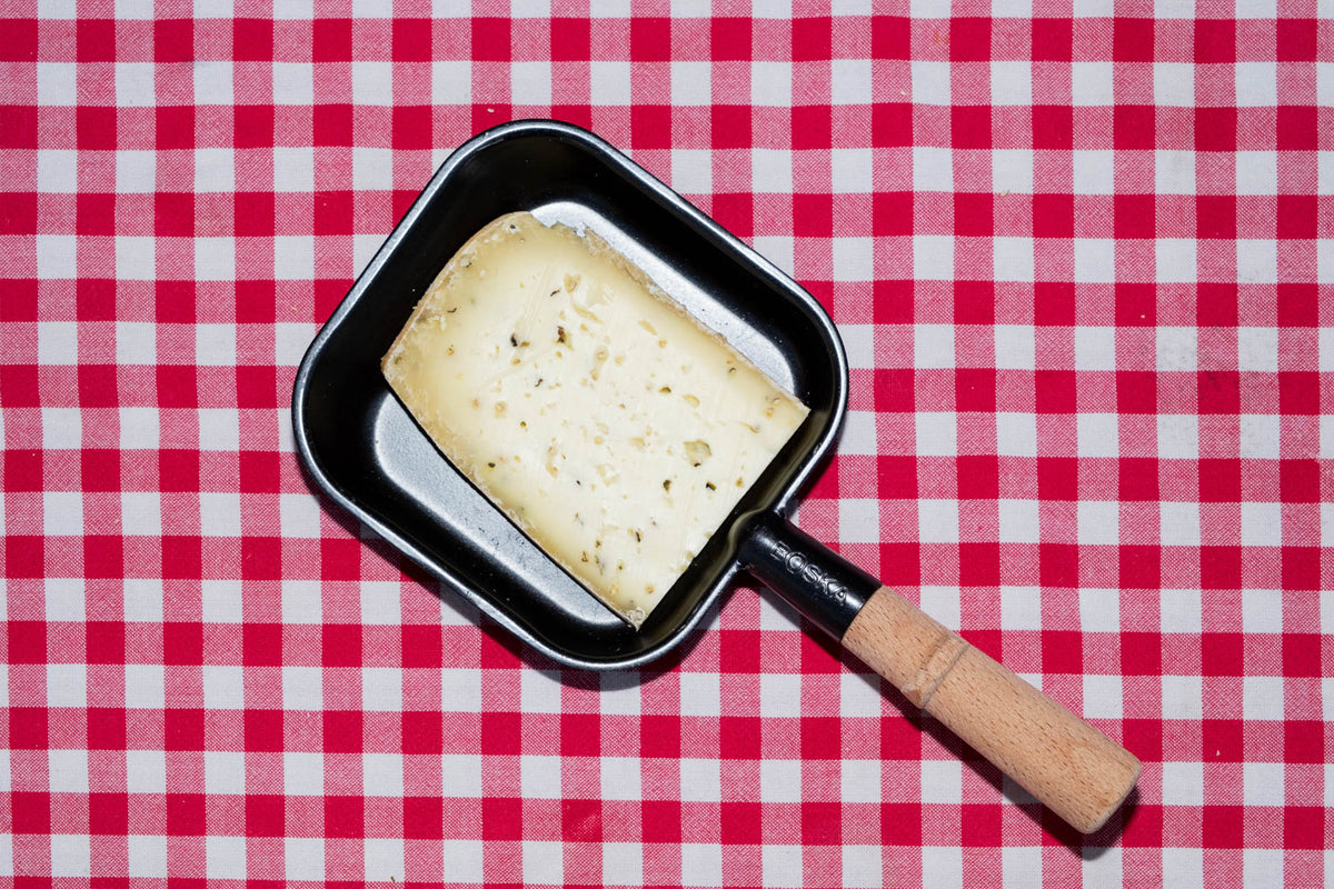 Raclette de Savoie au poivre, tranche dans un poêlon à raclette