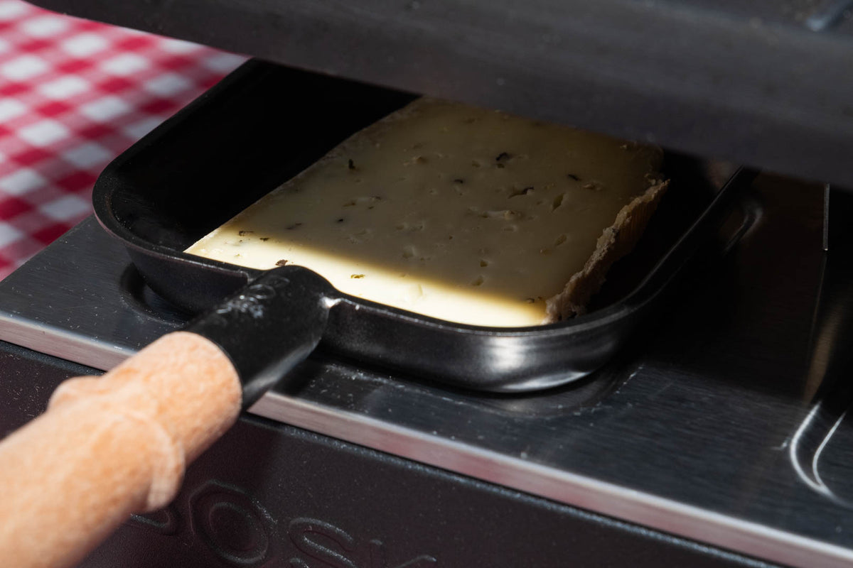 Raclette de Savoie au poivre, tranche qui fond sous l'appareil à raclette