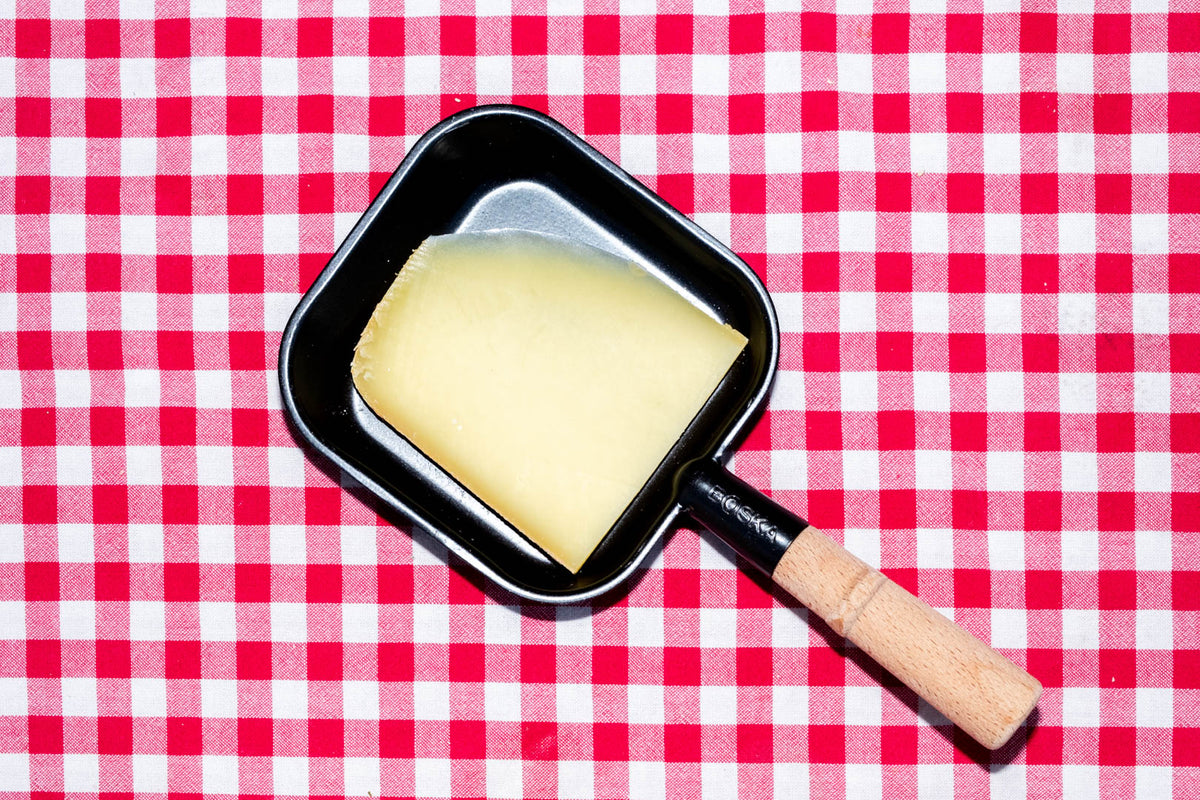 Raclette suisse de montagne, tranche dans un poêlon à raclette