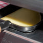 Raclette suisse de montagne, tranche qui fond sous l'appareil à raclette