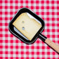 Raclette au vin blanc, tranche dans un poêlon à raclette