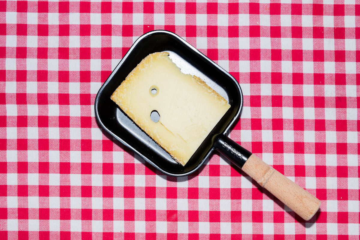 Raclette au vin blanc, tranche dans un poêlon à raclette