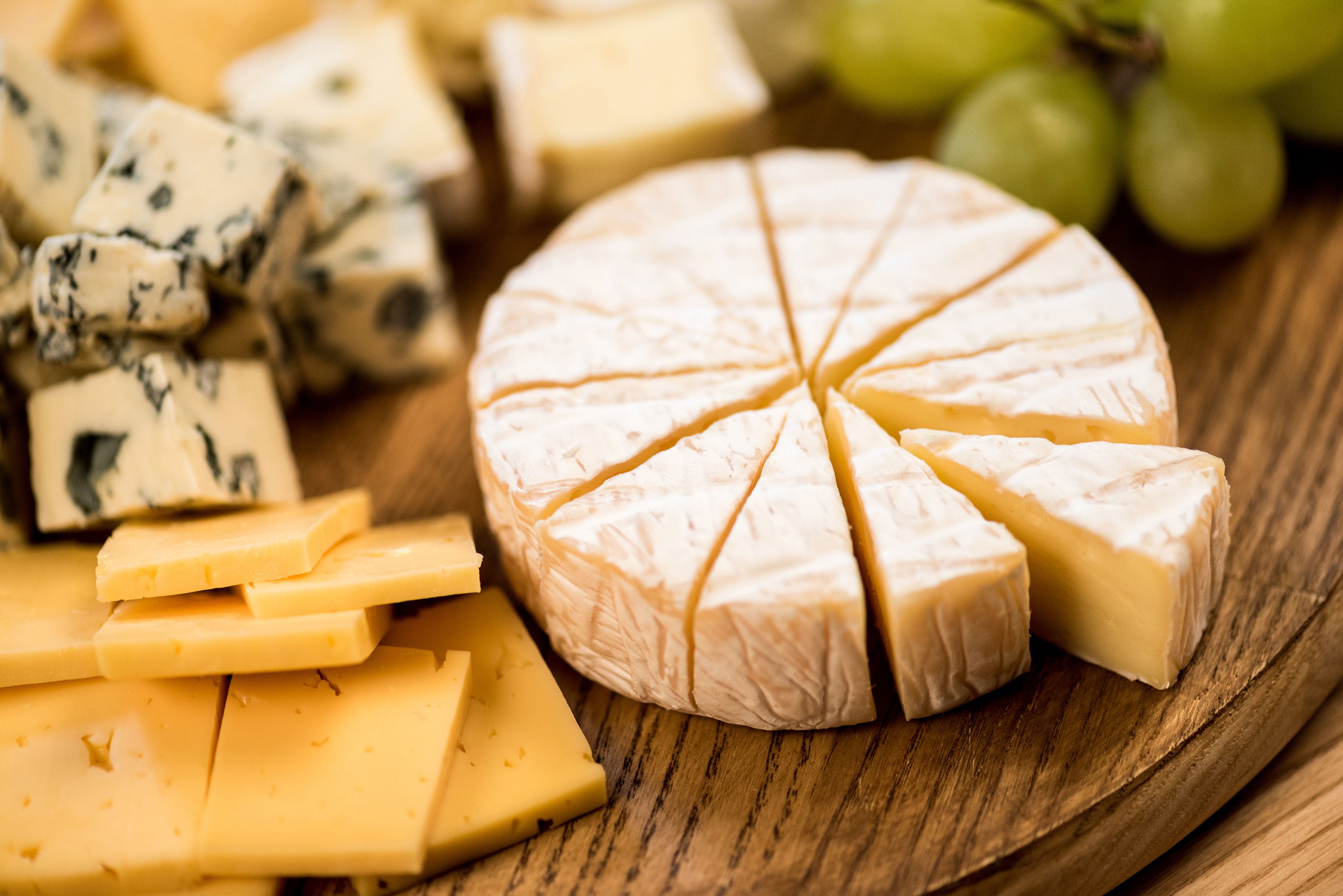 Plateau de fromages à pâte dure, à pâte molle et bleu, et raisins